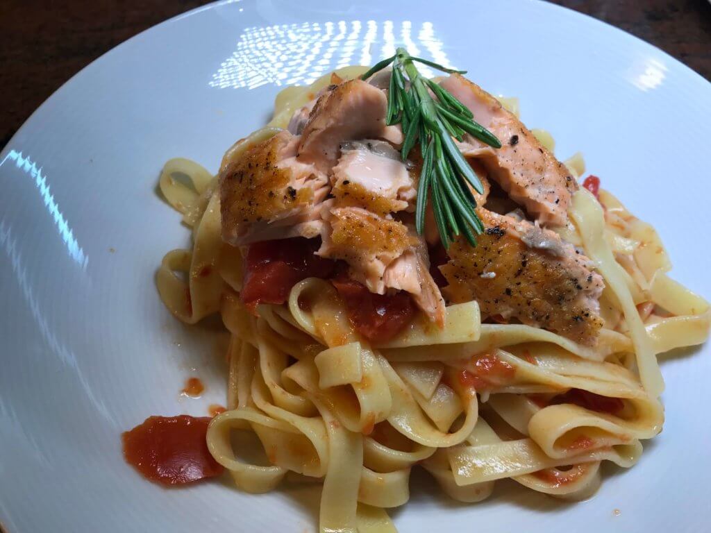 Lachs auf Tomatensauce und Breitbandnudeln